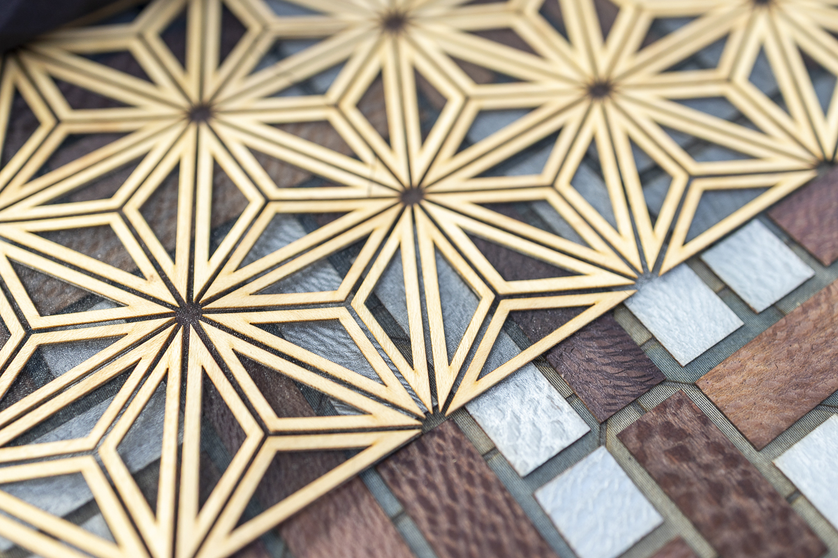 Detail of a geometric panel with upcycled wood on fabric, applied as a material in office design.