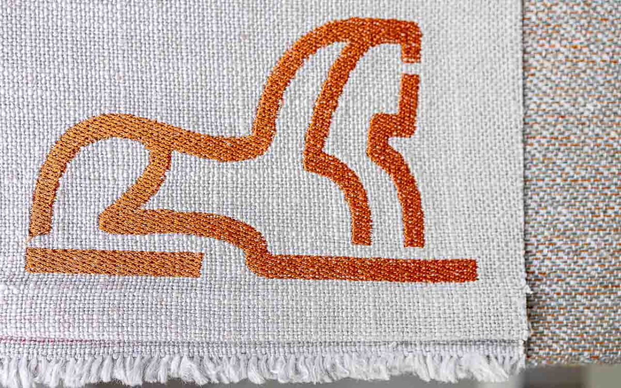 Custom logo embroideries on sustainable wall art and other objects